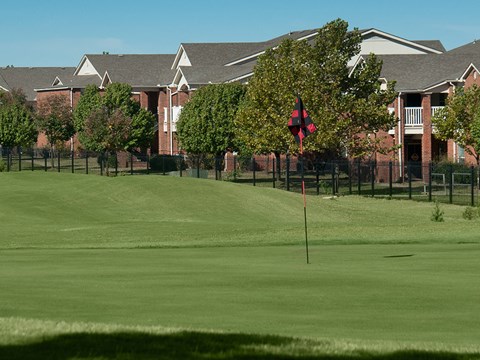 a view of a golf course with houses in the background