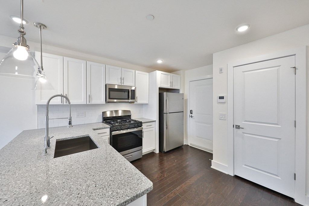 a kitchen with white cabinets and stainless steel appliances