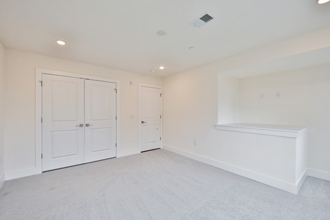 a bedroom with white walls and white closets and a white floor and white doors