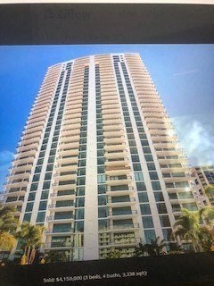 an image of an apartment building with palm trees