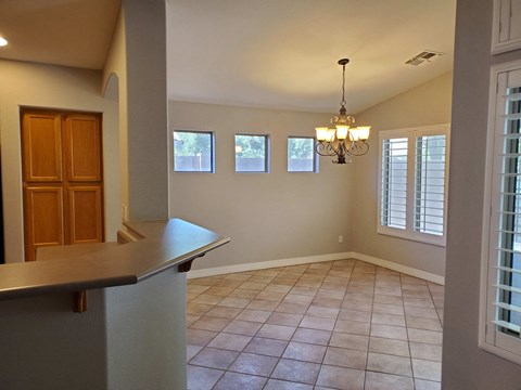 A kitchen with a counter and a chandelier.