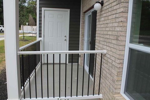 a front porch with a white door and a white railing