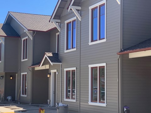 a row of houses with gray siding and blue windows