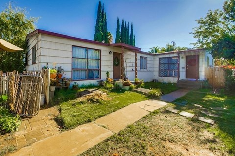 the front of a house with a yard and a sidewalk