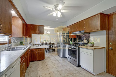 A kitchen with wooden cabinets and a white oven.
