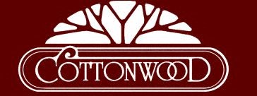 a sign for cottonwood with a tree in the background