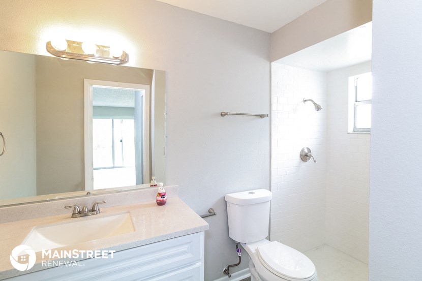 a white bathroom with a sink toilet and a mirror