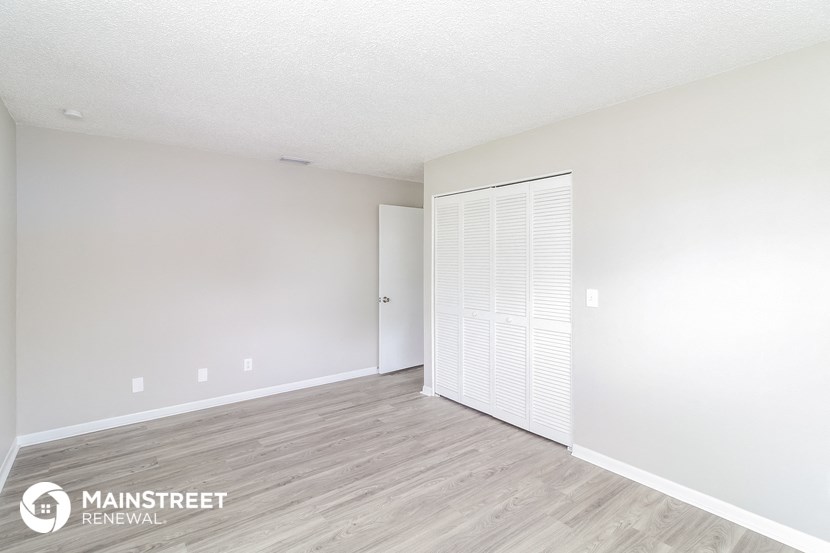 the living room and dining room of an apartment with a closet