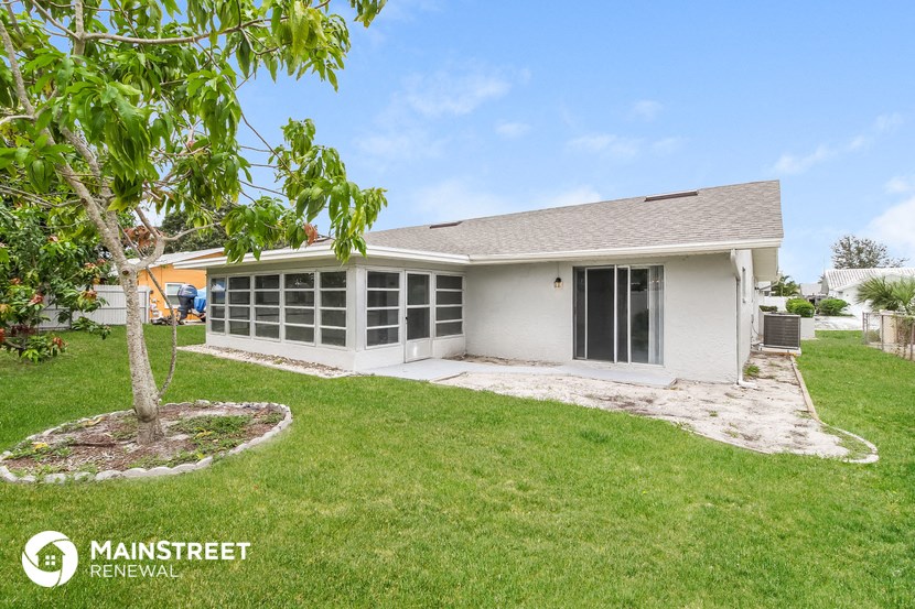 a white house with a yard and a tree