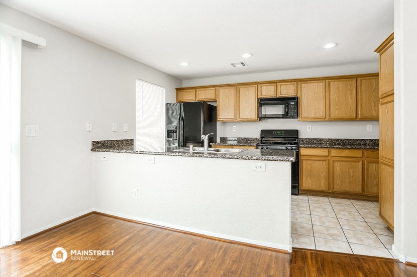 a kitchen with wooden cabinets and a white counter top