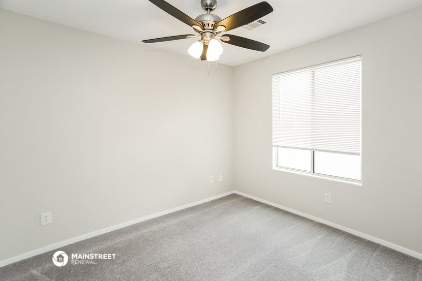 a bedroom with a ceiling fan and a window