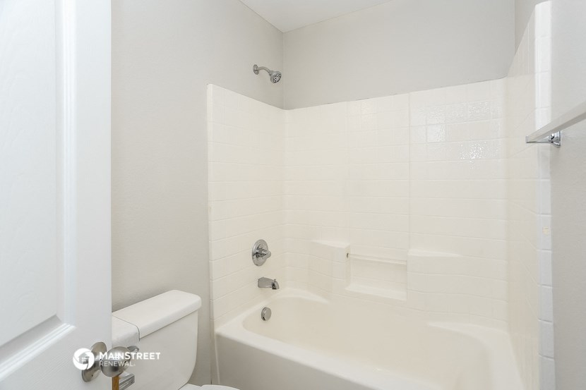 a white bathroom with a tub and a toilet