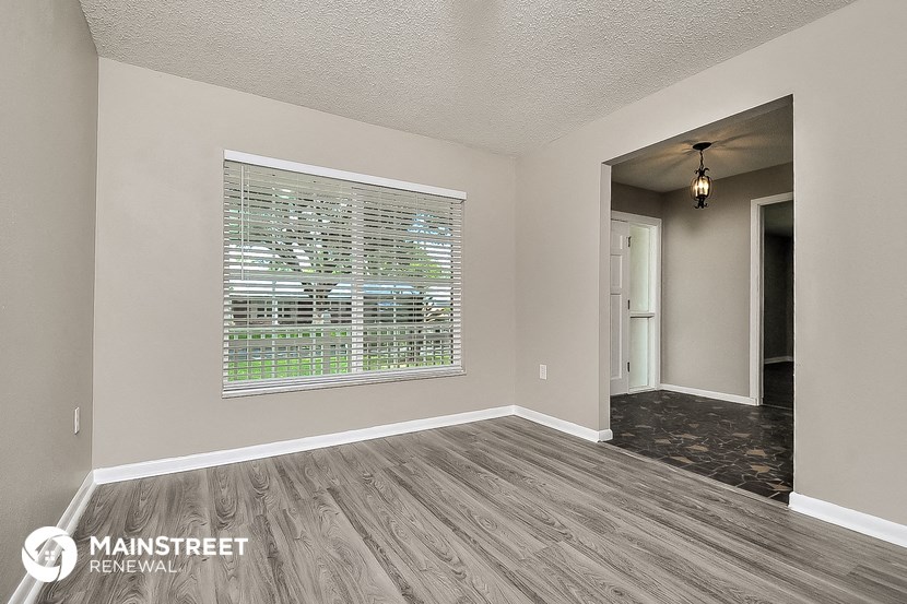 the spacious living room with a large window and wood flooring