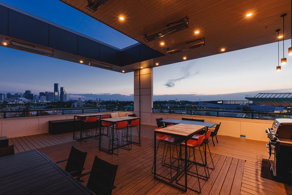A rooftop bar with a view of the city at dusk.