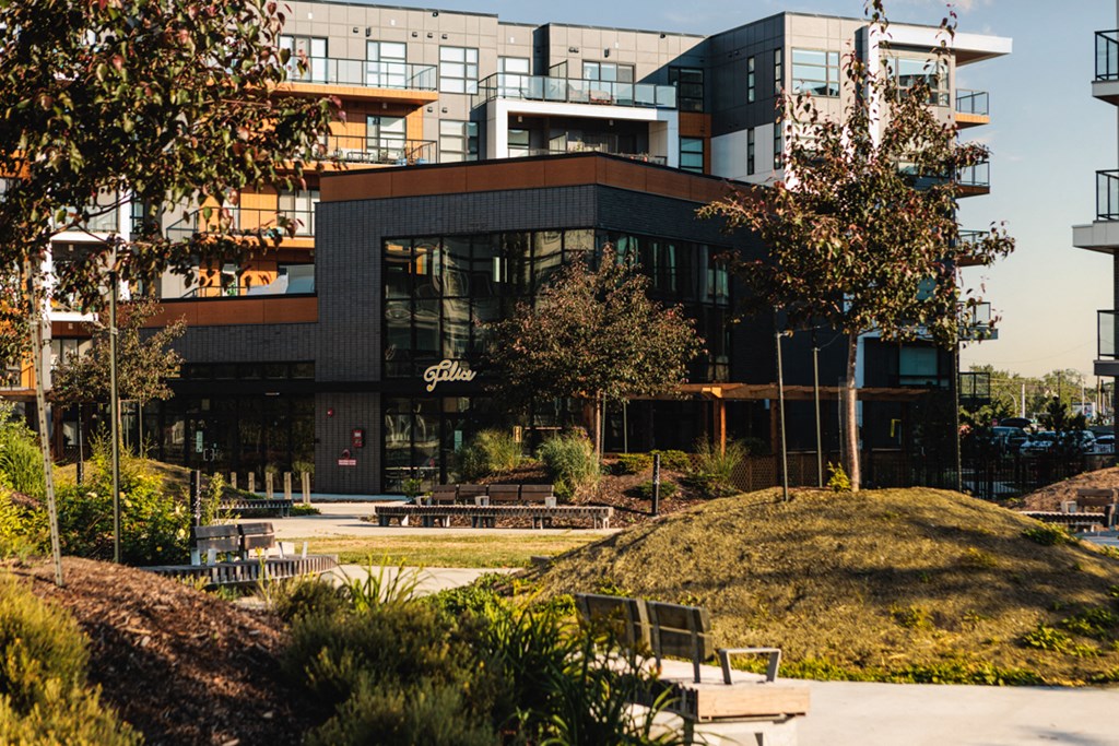 A modern building with a green hill in front of it.