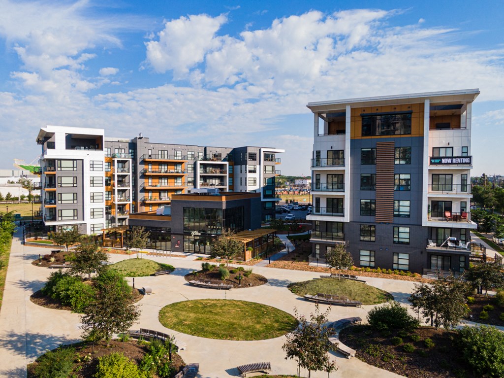 A modern apartment complex with a courtyard in the foreground.