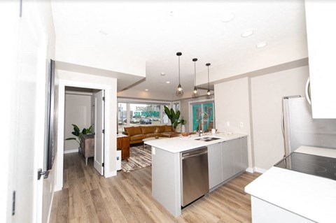 a kitchen and living room with a refrigerator and a sink