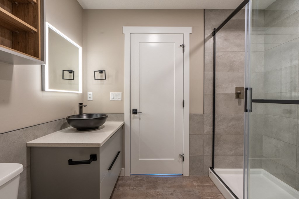 A bathroom with a white sink and a white door.