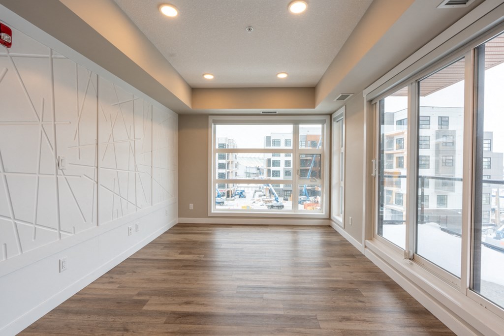 A long, empty room with wooden floors and white walls.