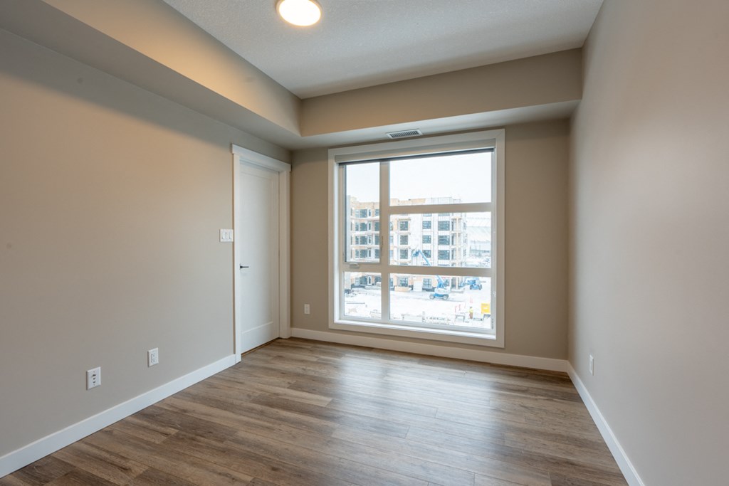 A room with a large window and wooden flooring.