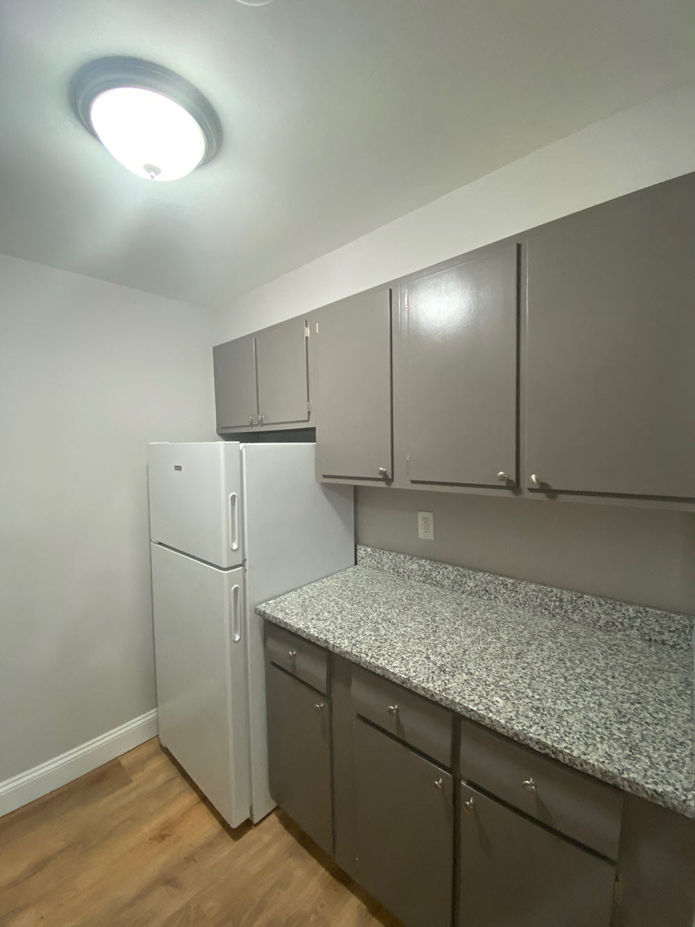 a kitchen with a granite counter top and a refrigerator