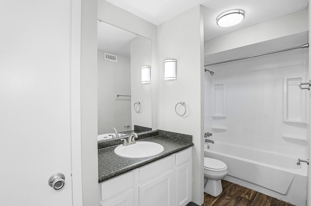 A bathroom with a sink, toilet, and bathtub.