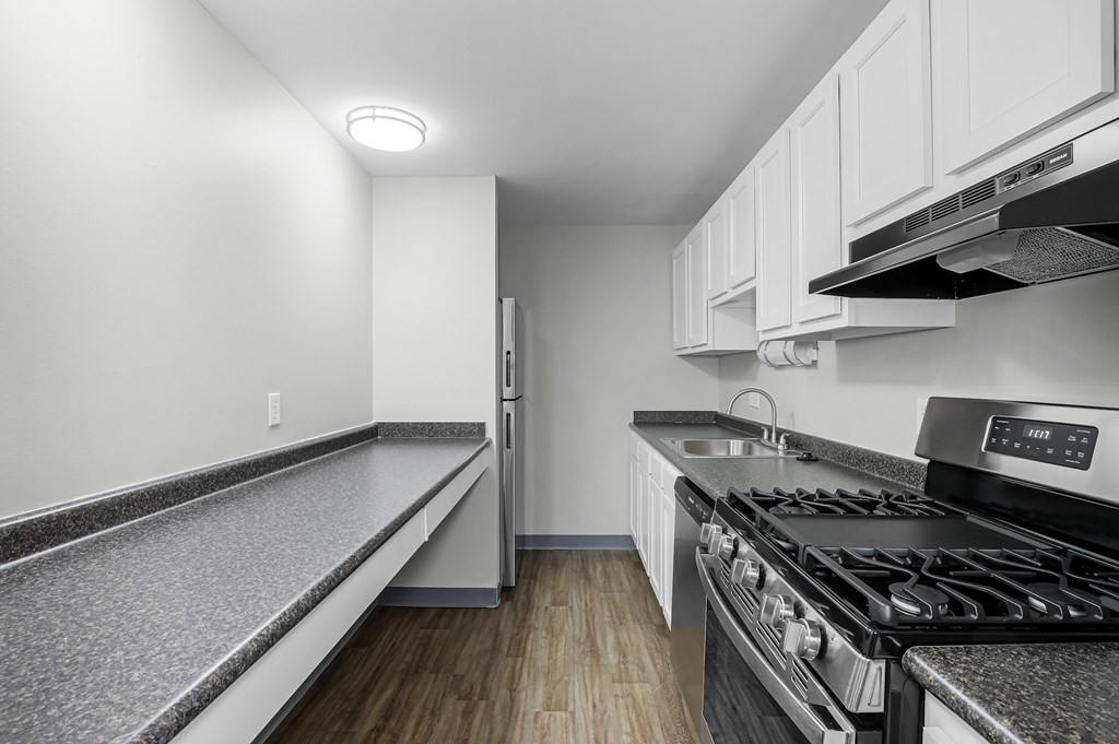 A modern kitchen with a stove top oven and a refrigerator.