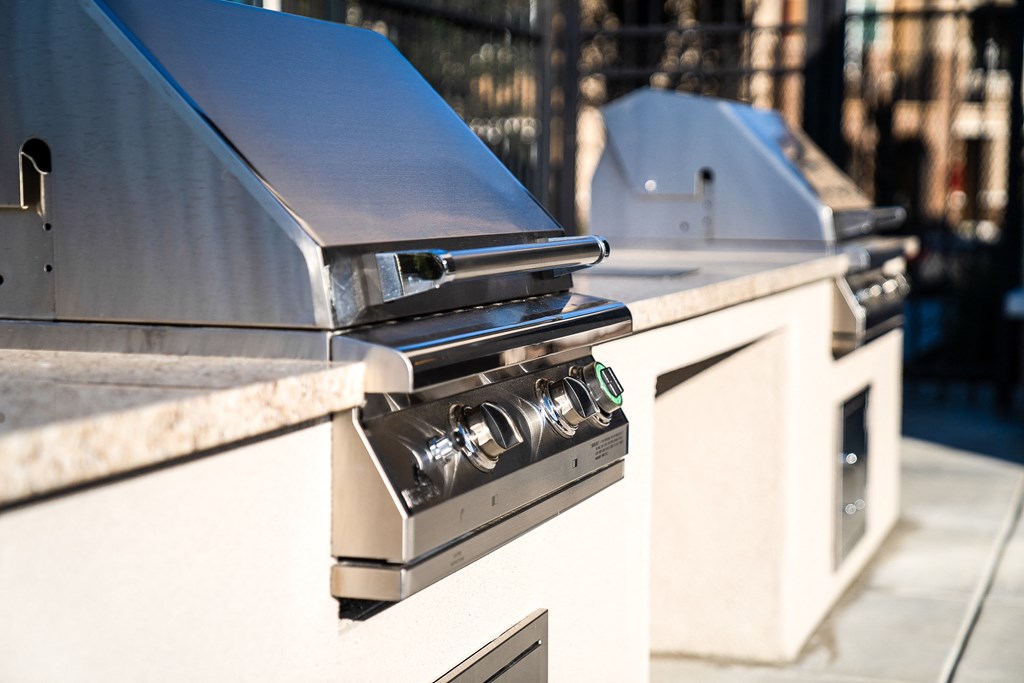 a stainless steel gas grill sitting on a barbecue grill