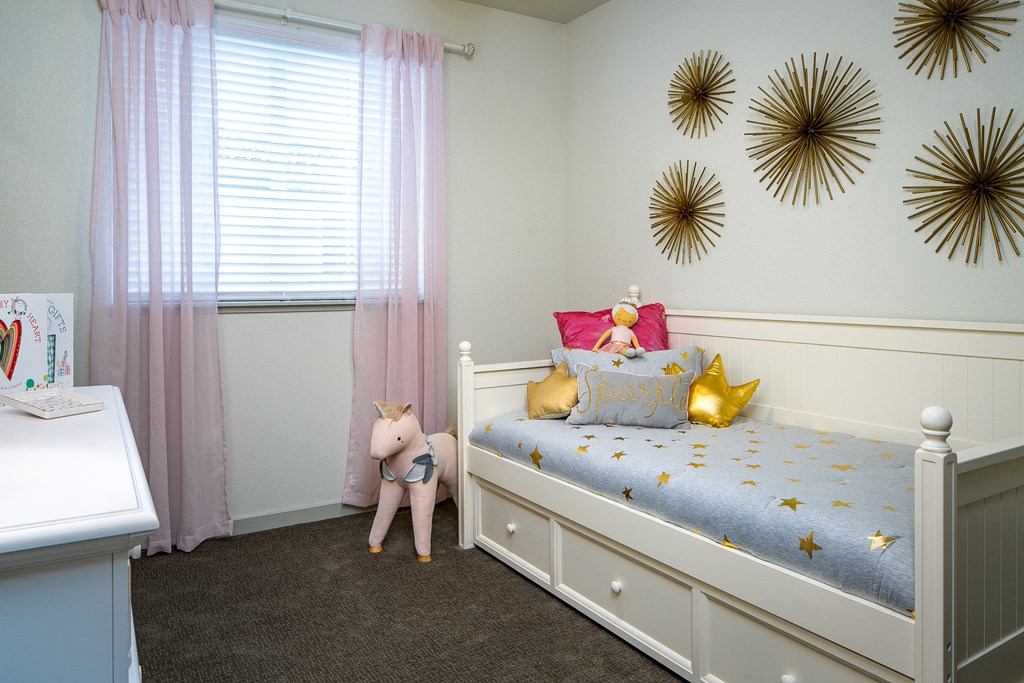 a childs bedroom with a bed and gold mirrors on the wall
