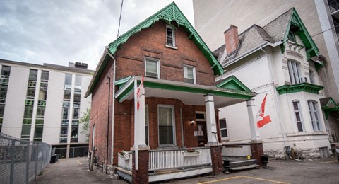 A red brick building with a green roof and white trim.
