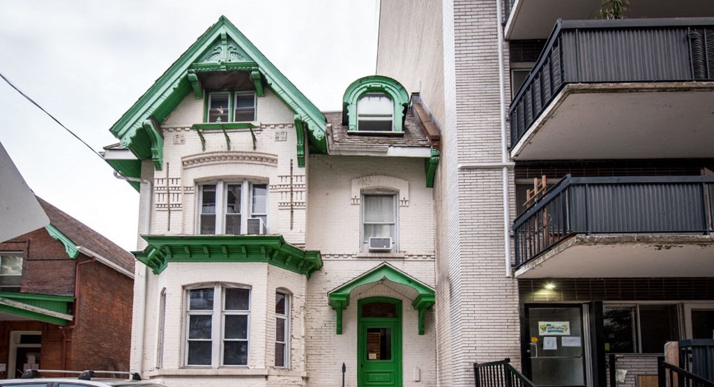 a white building with green trim and a green door