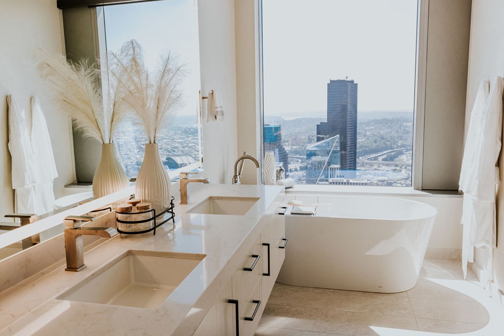 a bathroom with a tub and a view of the city