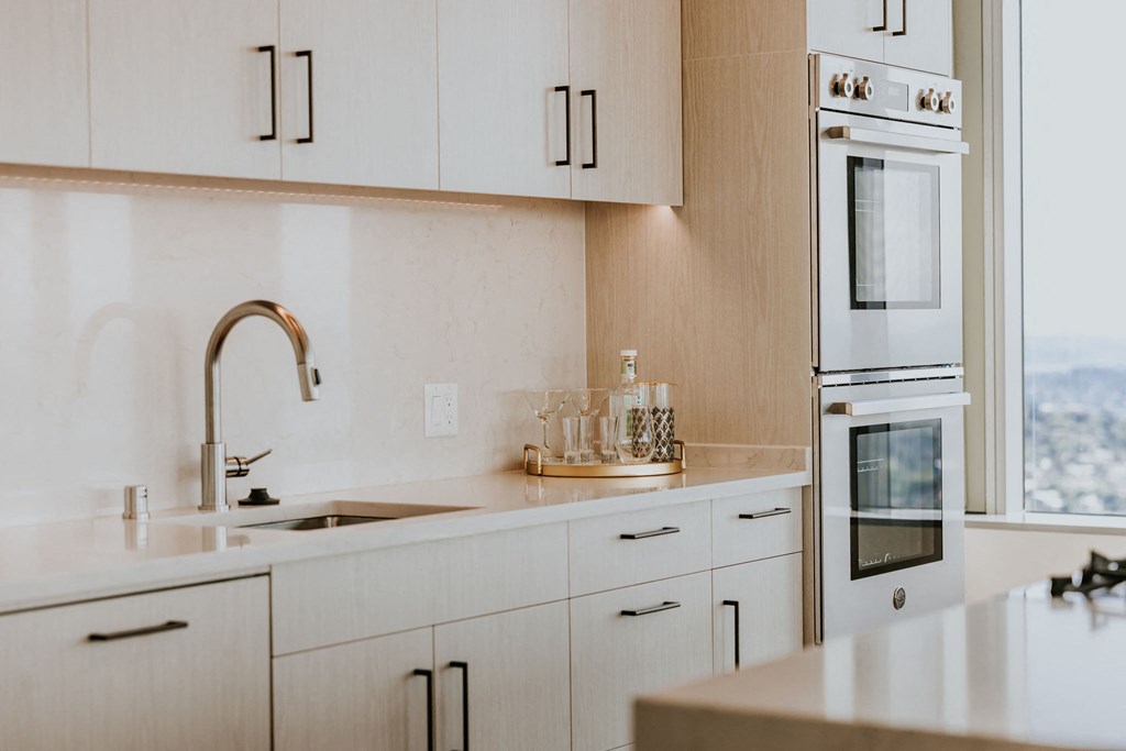 a kitchen with white cabinets and a sink and a window