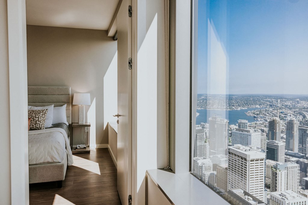 a bedroom with a view of the city and a bed and a window
