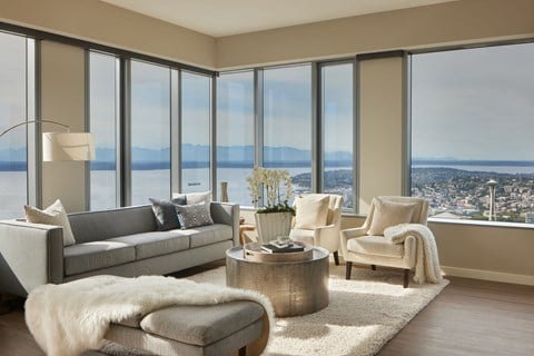 a living room with a view of the city and a couch and chairs