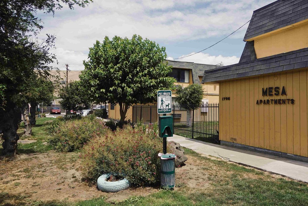 a parking meter in front of a yellow building