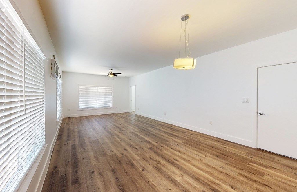 an empty living room with white walls and wood floors