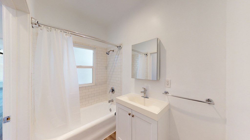 a bathroom with a sink and a tub and a shower curtain
