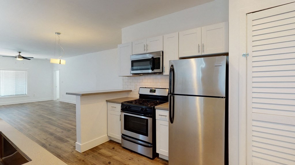 a kitchen with stainless steel appliances and white cabinets