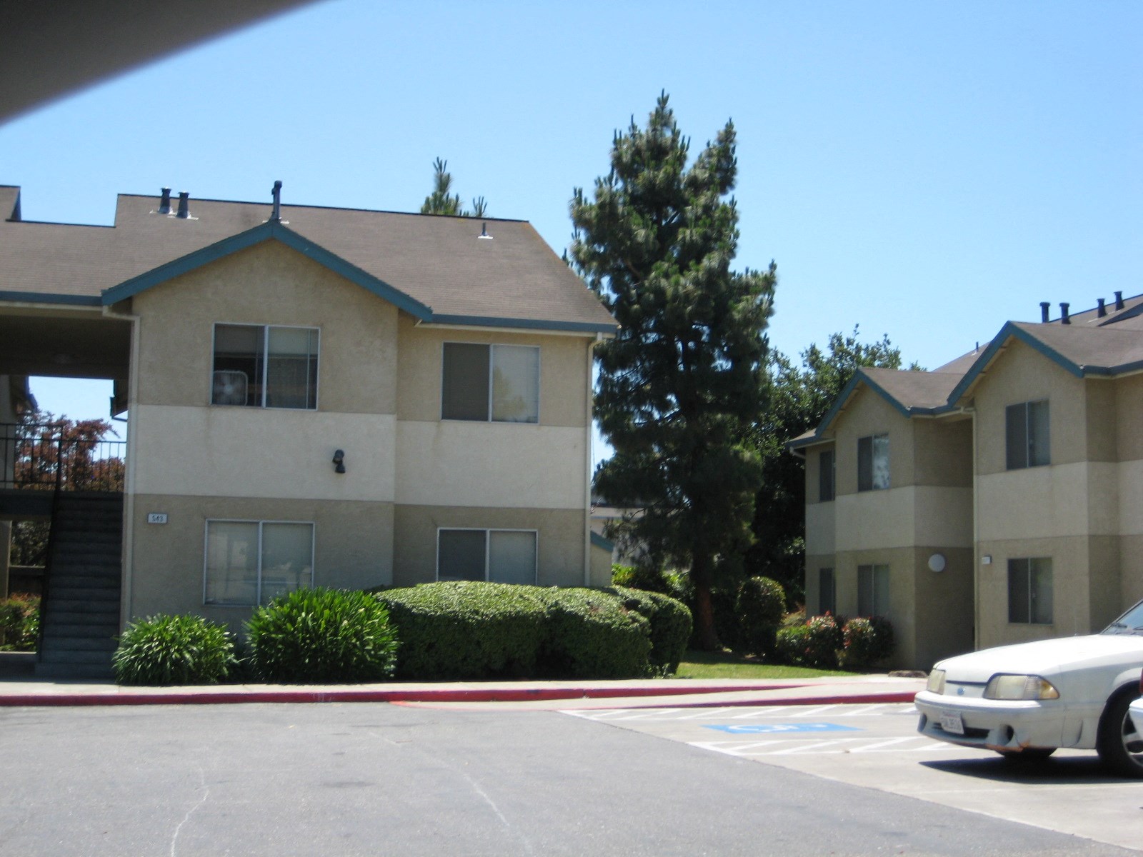 an apartment building in a parking lot with a car