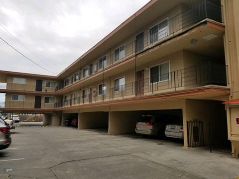 an apartment building with cars parked in a parking lot