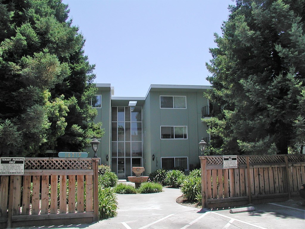 an apartment building with a courtyard and a wooden fence