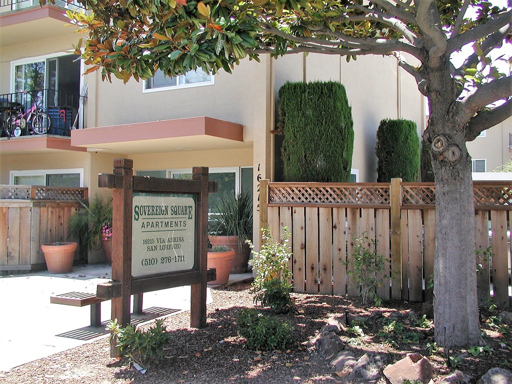 a building with a sign in front of a tree