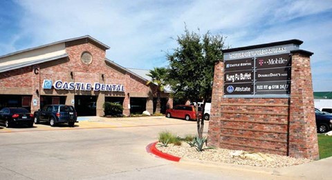 A brick building with a sign that says Castle Dental.