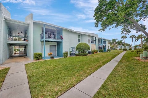 A row of modern houses with balconies and green lawns.