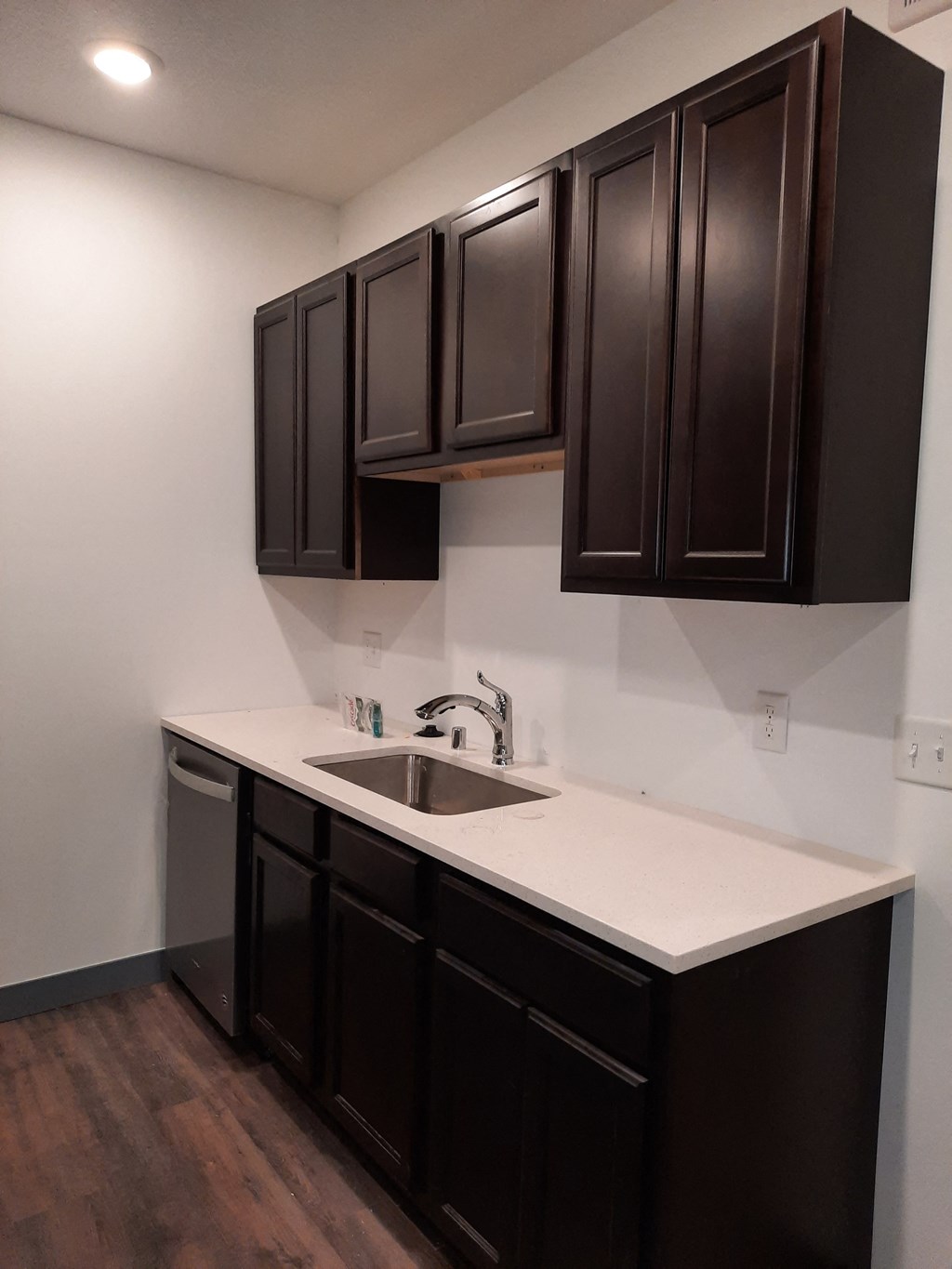 a kitchen with black cabinets and a white counter top and a sink