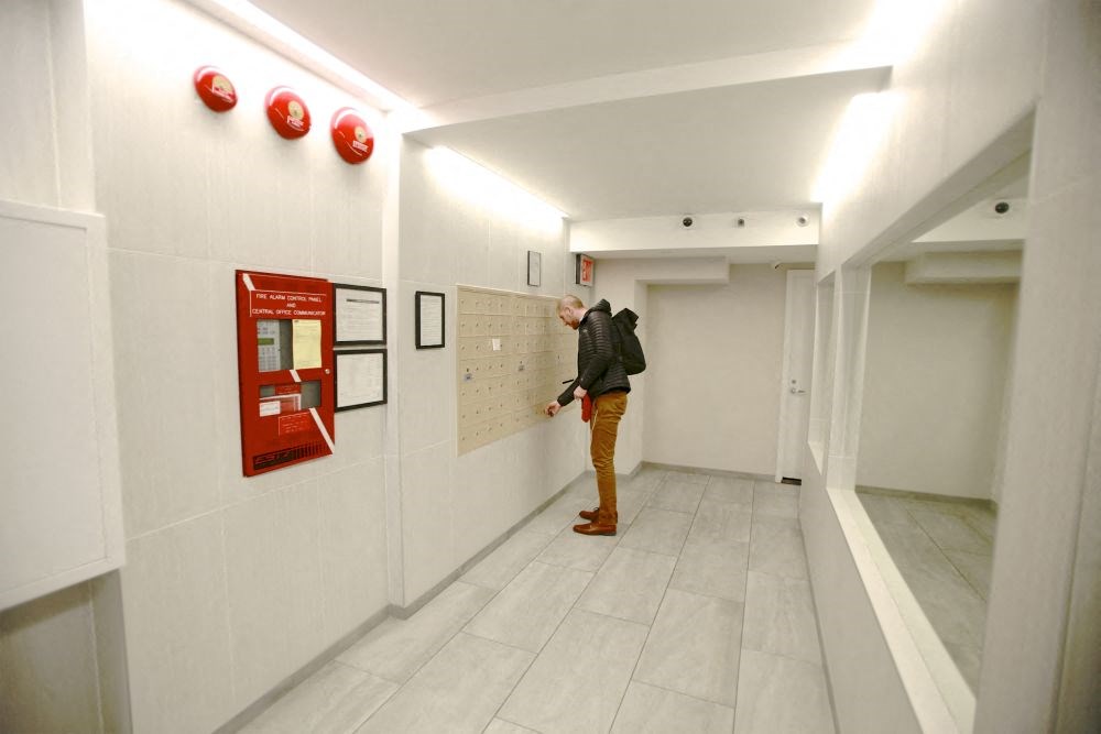 a man looking at a timetable on the wall of a building