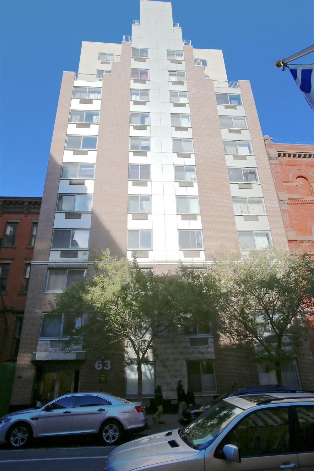 a tall building with cars parked in front of it