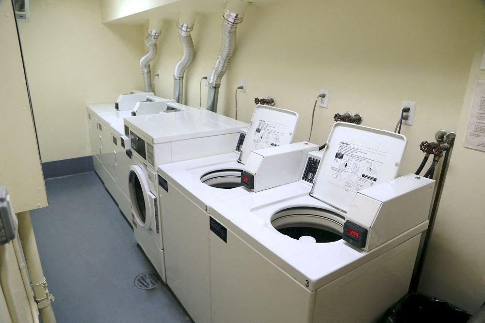 a washing machine and two dryers in a laundry room