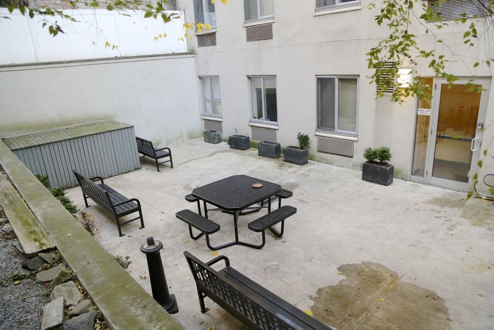 a patio with a table and chairs in front of a building